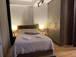 a bedroom with a bed with two pillows on it at Central Apartment Prishtina in Prishtinë