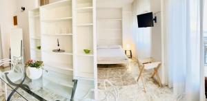 een kamer met witte muren, een bed en een bureau bij Guest House in Taranto