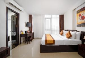 1 dormitorio con cama, escritorio y ventana en Hoa Phong Airport Danang Hotel, en Da Nang