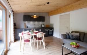 a kitchen and living room with a table and chairs at Alpinchalet in Pfronten +8 photos