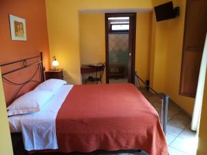 a bedroom with a large bed with a red blanket at Hotel Pace in Pompei