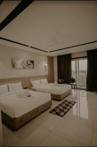 a hotel room with two beds and a large window at BANMALI PALACE in Kantābānji