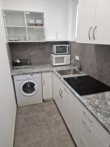 a small kitchen with a sink and a microwave at Cona rooms in Cerkvenjak