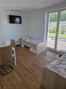 a room with two beds and a table and chairs at Cona rooms in Cerkvenjak