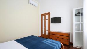 een slaapkamer met een bed en een tv aan de muur bij "Gold Fashion" - Residenza DUOMO Citylife in Milaan