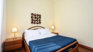 "Gold Fashion" - Residenza DUOMO Citylife في ميلانو: غرفة نوم عليها سرير وبطانية زرقاء