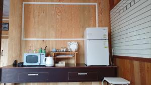 a kitchen with a counter with a refrigerator and a microwave at Yachtie Inn Yudal in Mokpo