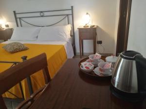 ポンペイにあるHotel Paceのベッドルーム1室(ベッド1台、テーブル、お茶ポット付)