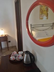 a mirror above a table in a room with a bed at Hotel Pace in Pompei
