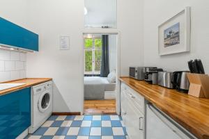 a kitchen with blue and white appliances and a bed at GreatStay Apartment - Gleditschstr. in Berlin