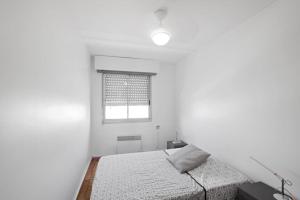 une chambre blanche avec un lit et une fenêtre dans l'établissement Appartement Calme et Moderne avec vue mer 74, à Canet