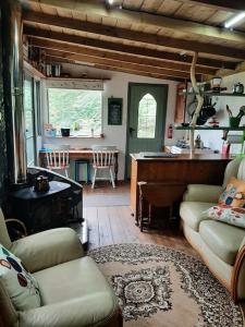 a living room with a couch and a table at Yn Y Coed Tanyrallt in Llanybyther