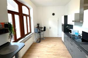 a kitchen with white walls and windows and a wooden floor at Nice Apartment in Lollar in Lollar