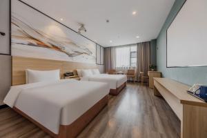 Ліжко або ліжка в номері Xinhuating Business Hotel