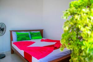 1 dormitorio con 1 cama con sábanas verdes y rojas en Keth Sisila Villa, en Dambulla