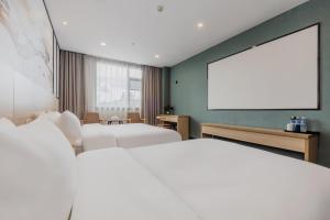 Ліжко або ліжка в номері Xinhuating Business Hotel