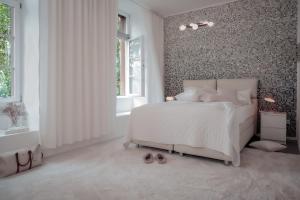 a bedroom with a white bed and a patterned wall at Boutique Suites Heidelberg Alte Zigarrenmanufaktur in Heidelberg