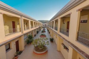 ヴィッラシミーウスにあるISA-Residence with swimming-pool in Villasimius, apartments with air conditioning and private outdoor spaceの鉢植えのアパートメントビルの空廊