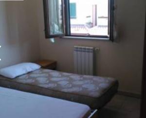 - une petite chambre avec un lit et une fenêtre dans l'établissement Villetta in residence privato totale relax, à Campomarino