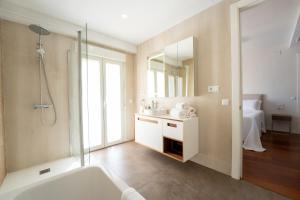 a bathroom with a tub and a sink and a mirror at Plaza Mina Suites - Adults Recommended by Luxury Suites Cadiz in Cádiz +37 photos