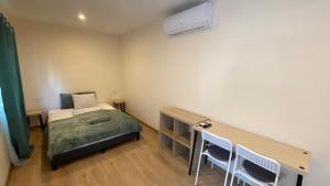 a bedroom with a bed and a desk with chairs at Night & Flight Airport Apartman in Vecsés