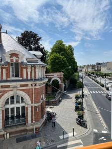 Blick auf eine Straße mit einem Backsteingebäude in der Unterkunft Hôtel Belle Fontainebleau in Fontainebleau