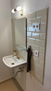 a white bathroom with a sink and a mirror at Night & Flight Airport Apartman in Vecsés