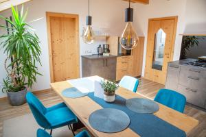 a kitchen and dining room with a wooden table and blue chairs at Apt Lara Ruveda in Ortisei