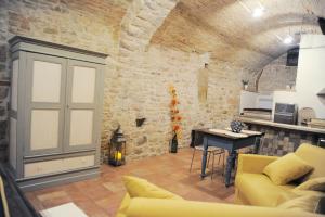 a living room with a couch and a stone wall at O rosa bella Appartamento via savelli della porta 24 in Gubbio