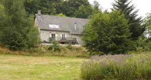 a stone house with a balcony in a field at Une pause en Corrèze in Sarroux