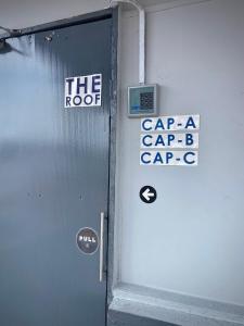 una puerta de metal con una señal en el lateral de un edificio en GRAYHAUS INN Ipoh en Ipoh