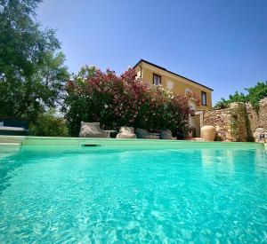 una grande piscina di acqua blu di fronte a una casa di La Foresteria di Serracavallo a Bisignano