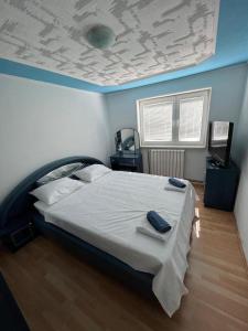 ein Schlafzimmer mit einem großen Bett mit blauer Decke in der Unterkunft Villa Dalia in Sarajevo