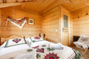 コシチェリスコにあるDomki Cepersko Ostoja w Kościeliskuの木造キャビン内のベッド1台が備わるベッドルーム1室を利用します。