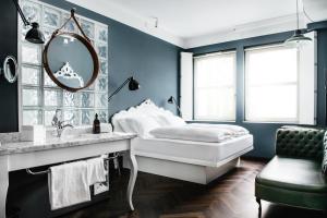 a blue bedroom with a bed and a mirror at Grand Ferdinand Vienna – Your Hotel In The City Center in Vienna