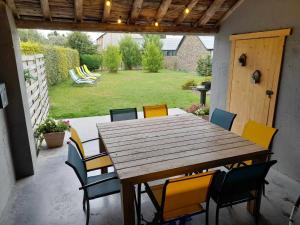una mesa de madera y sillas en un patio en Le refuge de Julia, en La-Roche-en-Ardenne