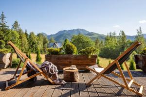 a woman laying in a chair on a deck at Domki Cepersko Ostoja w Kościelisku in Kościelisko