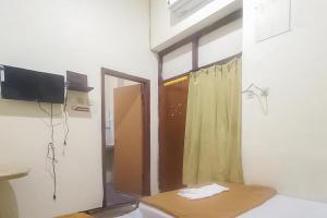 a room with a door and a window with a curtain at Hotel Malang near Alun Alun Malang RedPartner in Malang