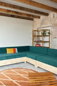 a blue couch in a room with a brick wall at Suvelfabryk in Lioessens