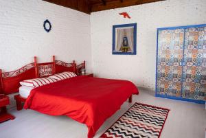 a bedroom with a red bed with a red blanket at Narcicegi Hotel in Cıralı