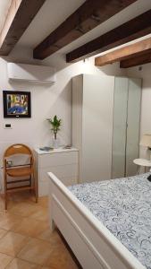 ein Schlafzimmer mit einem Bett, einem Tisch und einem Stuhl in der Unterkunft Fiore della Laguna in Venedig
