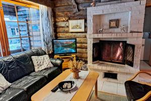 a living room with a couch and a fireplace at Kielaslinna above the Arctic Circle in Suomutunturi