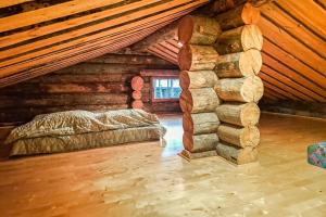 a room with a bed and a stack of logs at Kielaslinna above the Arctic Circle in Suomutunturi