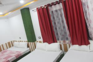 two beds in a room with red curtains at Hotel Giggle Coast Restro and Lodge in Birtamode