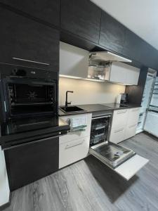 cocina con armarios negros y horno con fogones en SWID Appartement 9, en Delitzsch