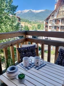 a table with two coffee cups on a balcony at Studio Chalet 13, St John Park Bansko in Bansko