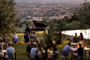 a group of people sitting at tables with a piano at La Quercetta in Foligno