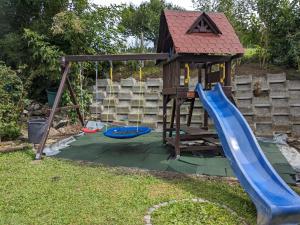 einen Spielplatz mit Rutsche und Spielhaus in der Unterkunft Apart Hotel near Lucerne in Ruswil