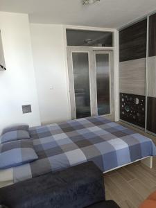 a bedroom with a checkered bed and a window at Studio Lara in Zagreb
