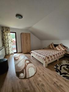 a bedroom with two beds and a large window at Casa Alba in Borşa